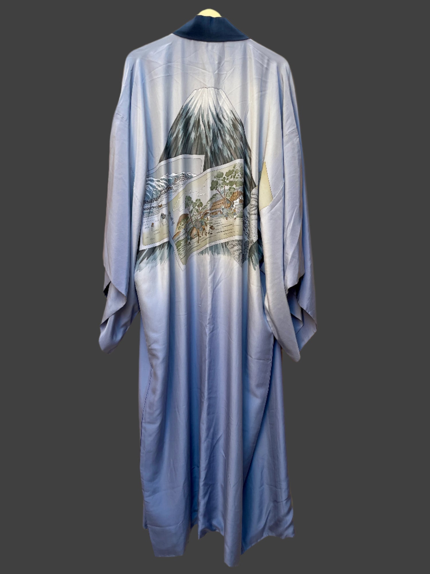 Blue kimono with mountain and landscape design on a beige background